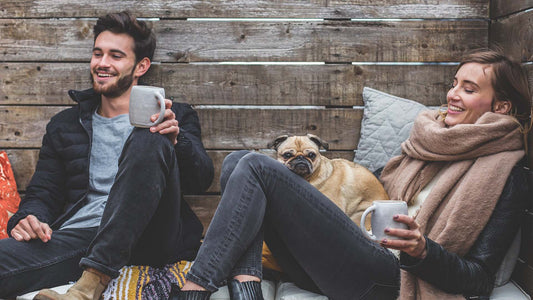 Smiling man and woman sitting with pug