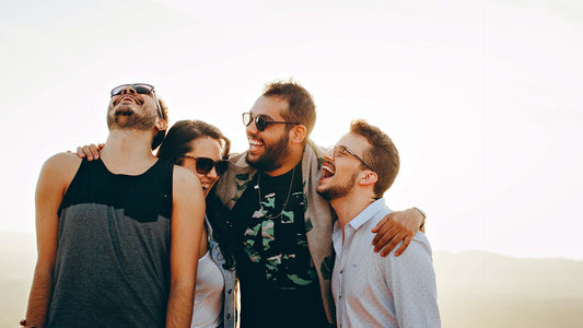 Four friends embracing and laughing