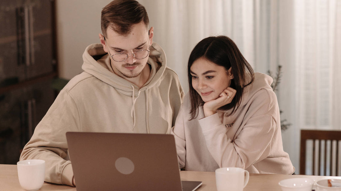 A couple simultaneously looking at the laptop